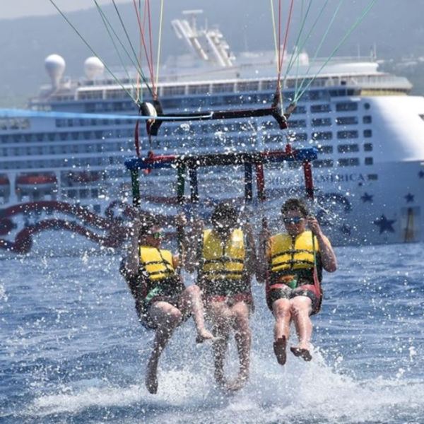 a man riding on the back of a boat in the water