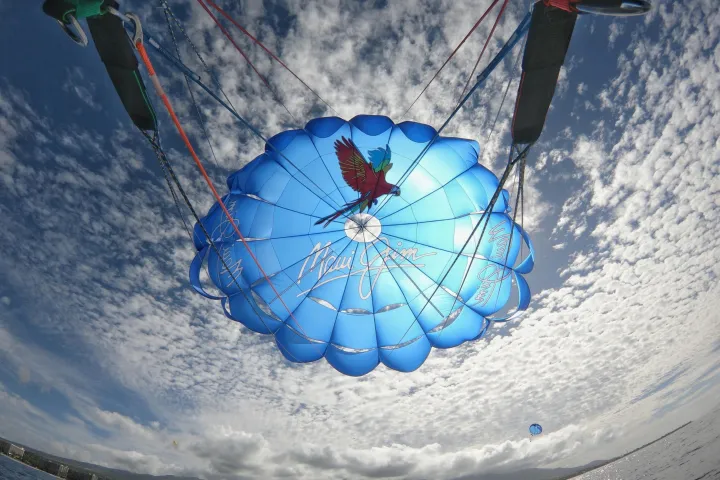 a blue and white kite flying high in the air