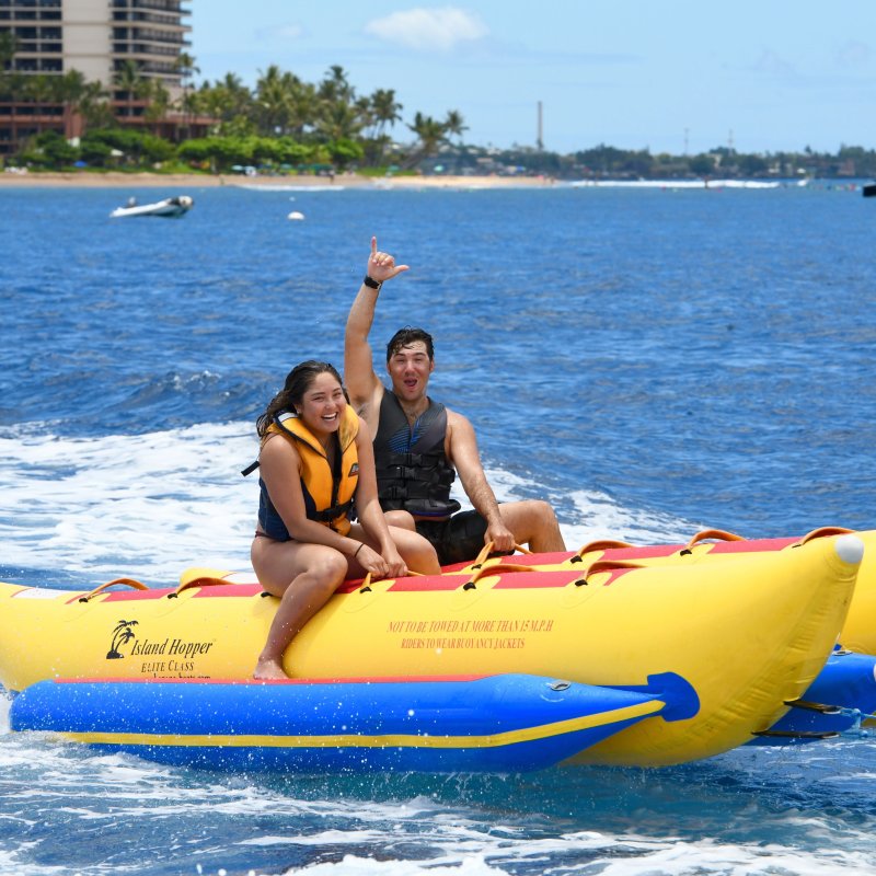 a little girl riding on the back of a boat in the water