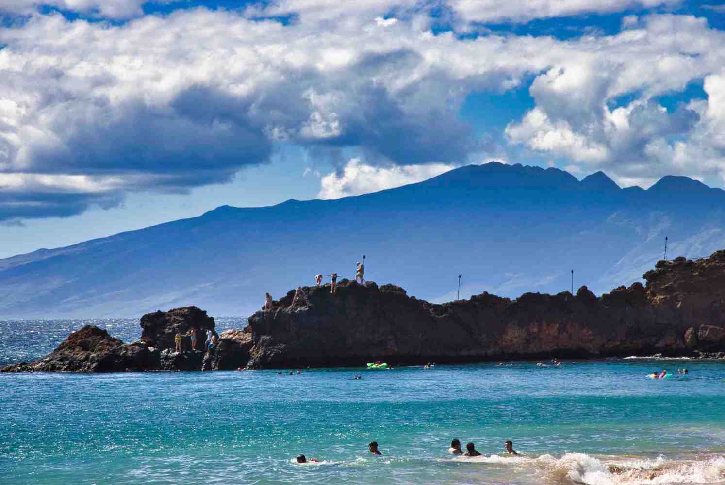 a large body of water with a mountain in the background